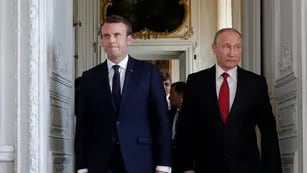 French President Emmanuel Macron walks with Russian President Vladimir Putin at the Chateau de Versailles as they meet for talks before the opening of an exhibition marking 300 years of diplomatic ties between the two countries in Versailles