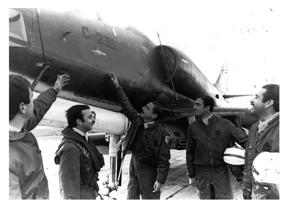 Foto tomada el 13 de mayo de 1982, alférez Vázquez (quien moriría en combate el 8 de junio), alférez Dellepiene (quien fue el piloto de ese avión), a su lado y señalando el vicecomodoro y Jefe de Escuadrón Douburg, detrás, con el casco el teniente Amarrás y a la derecha, capitán Zelaza. Foto Fuerza Aérea Argentina
 
