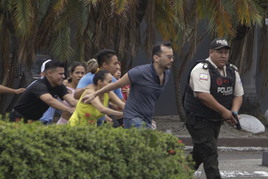 La policía evacúa a personal del canal TC Televisión después de que un grupo armado y encapuchado irrumpiera en plena transmisión en directo, en Guayaquil, Ecuador (AP Foto/César Muñoz)