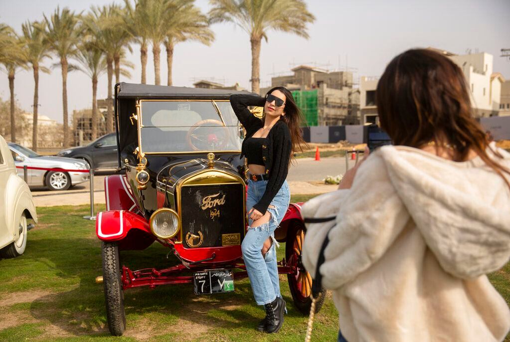 La entusiasta de los coches clásicos Carine Sherif posa frente a un Ford Modelo T de 1924, propiedad del coleccionista egipcio Mohamed Wahdan, durante una exhibición de automóviles clásicos el sábado 19 de marzo de 2022, en El Cairo, Egipto. El vehículo perteneció alguna vez al rey Farouk de Egipto y forma parte de más de 250 coches vintage, antiguos y clásicos que Wahdan ha coleccionado durante los últimos 20 años. (AP Foto/Amr Nabil)