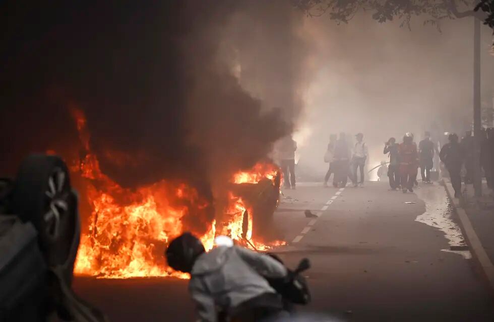 Un incendio arde en medio de una calle durante los enfrentamientos entre manifestantes y la policía antidisturbios francesa luego de una marcha en memoria de Nahel, de 17 años, quien fue asesinado por la policía francesa en Nanterre, cerca de París, Francia. Foto: EFE/EPA/YOAN VALAT